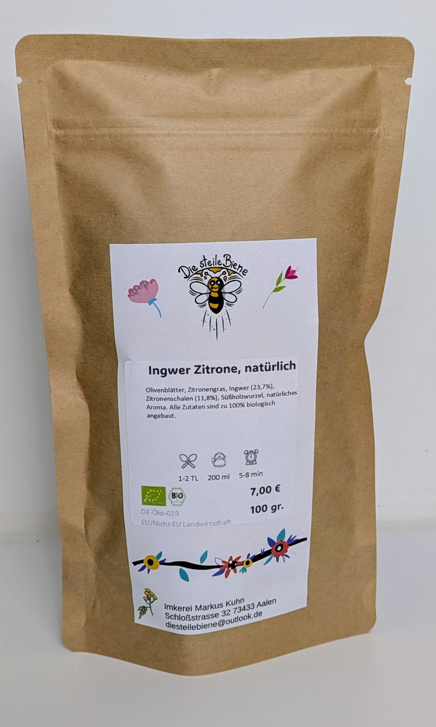 Loser Bio Ingwer-Zitronen-Tee in einer weißen Tasse mit frischer Ingwerscheibe und Zitronenscheiben auf einem Holzbrett